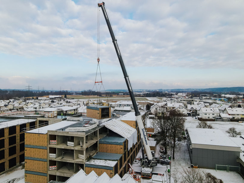 Liebherr LTM 1450-8.1 mobile crane couples timber modules with reinforced concrete carcass for care home